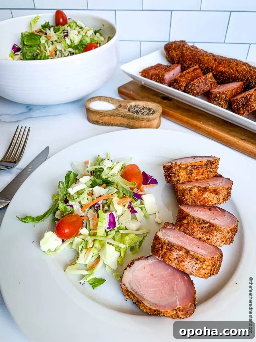 Quick Summer Dinner Recipes for Lazy Weeknights 14 Slices of smoked pork tenderloin with salad on a dinner plate and on a platter in the background.