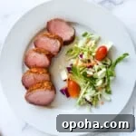 Quick Summer Dinner Recipes for Lazy Weeknights 15 Slices of smoked pork tenderloin on a white dinner plate with a side salad.