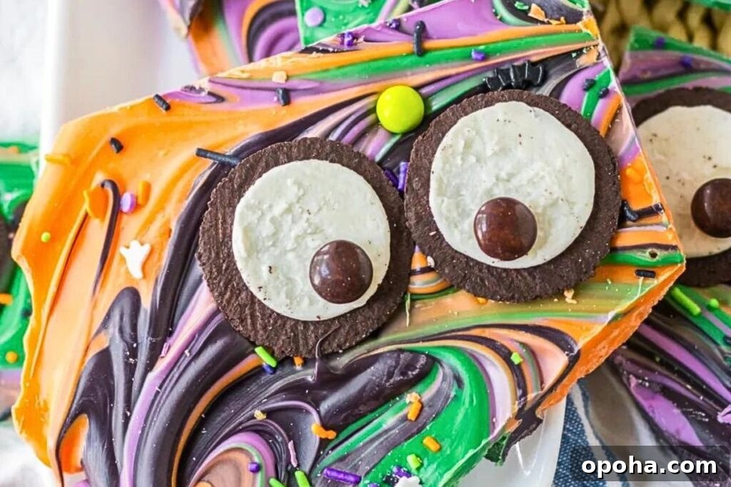 18 Spooky Halloween Movie Night Snacks to Delight Your Guests 16 Colorful candy bark with oreo eyes.