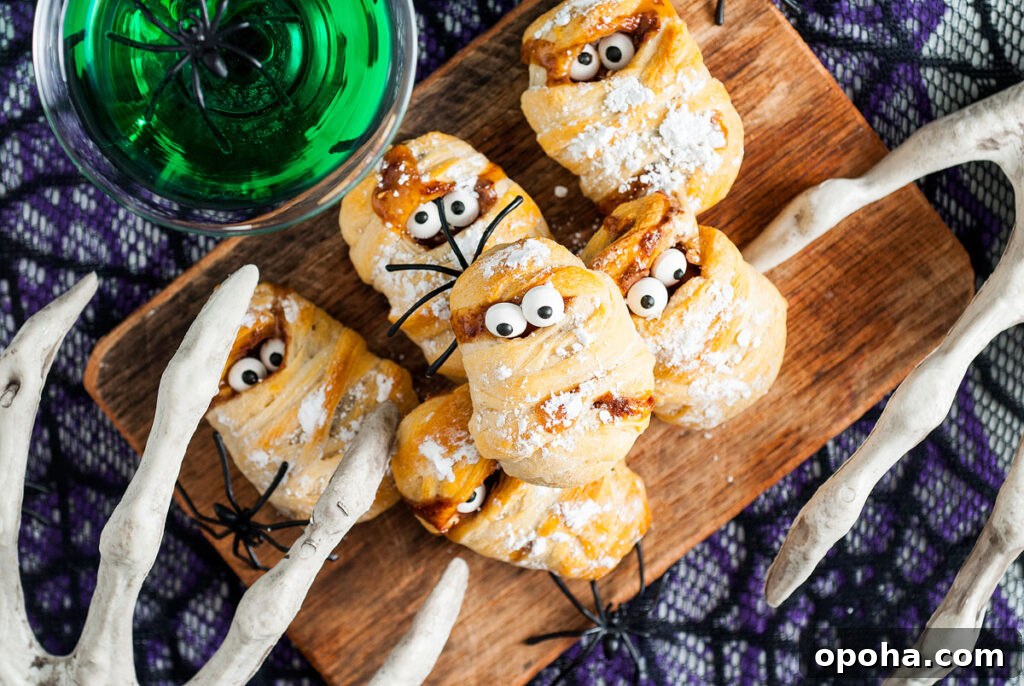 18 Spooky Halloween Movie Night Snacks to Delight Your Guests 4 Halloween Snickers Mummy Treats on a cutting board