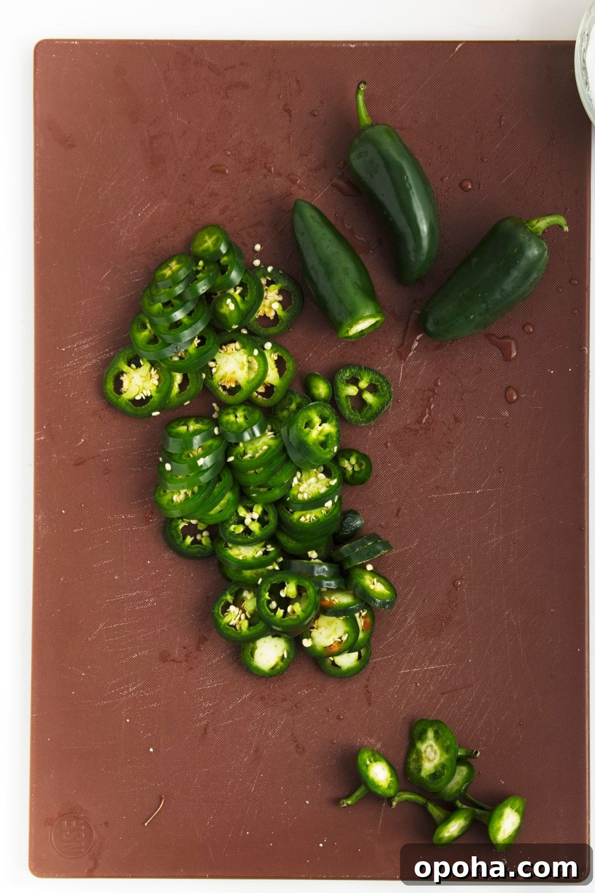 Candied Jalapeños (Cowboy Candy) Recipe for Sweet-Spicy Pickled Peppers 5 sliced jalapenos on a cutting board