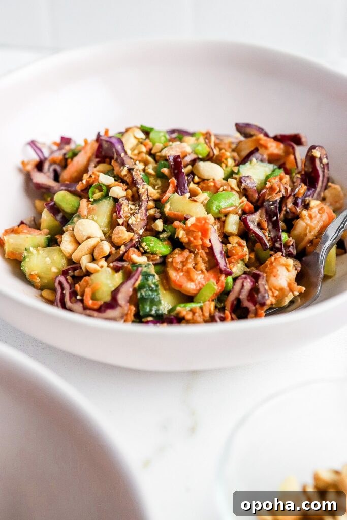 crispy rice salad with thai peanut dressing in white bowl with shrimp and fresh veggies