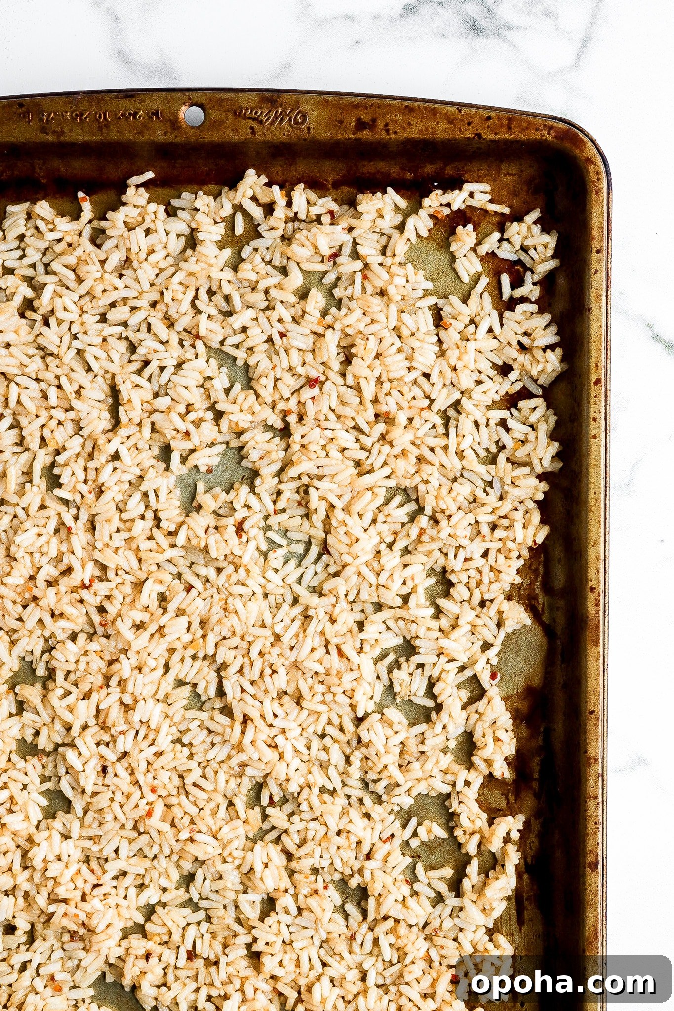 Top down view of rice on baking sheet ready for the oven