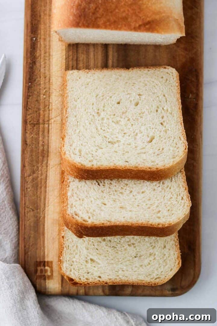 Three slices of Soft and Tender Buttermilk Bread on cutting board.