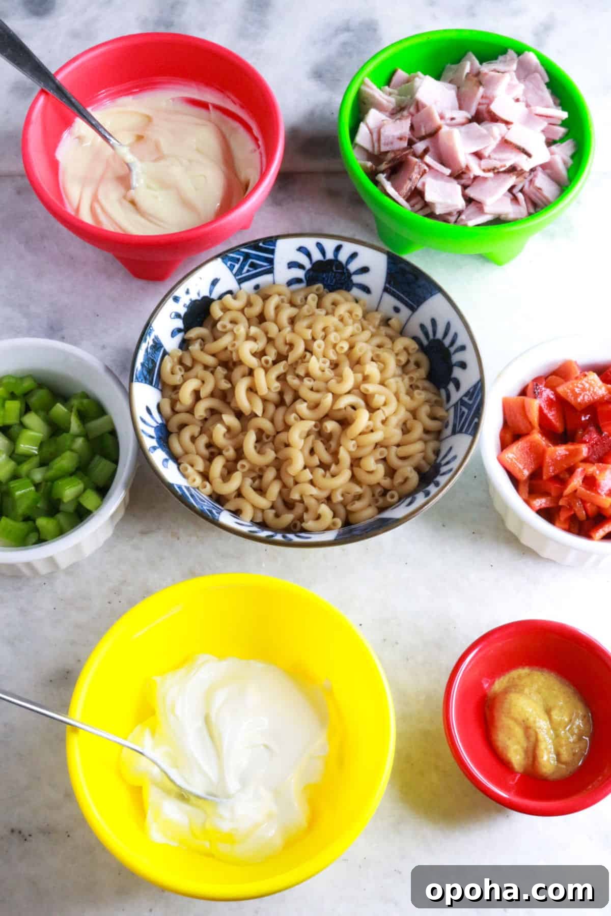 Mexican Macaroni (Ensalada de Coditos) — Creamy Cold Pasta Salad 3 Bowls with sour cream, diced ham, chopped celery, macaroni noodles, roasted bell pepper, mayo, and mustard.