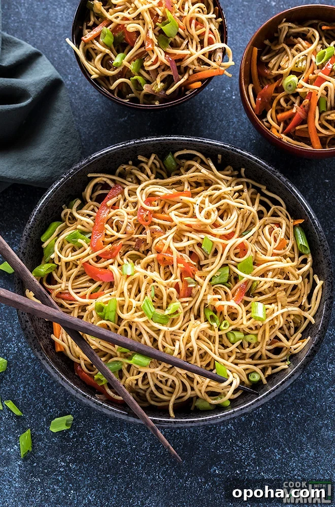 hakka noodles in a black bowl with a pair of chopsticks