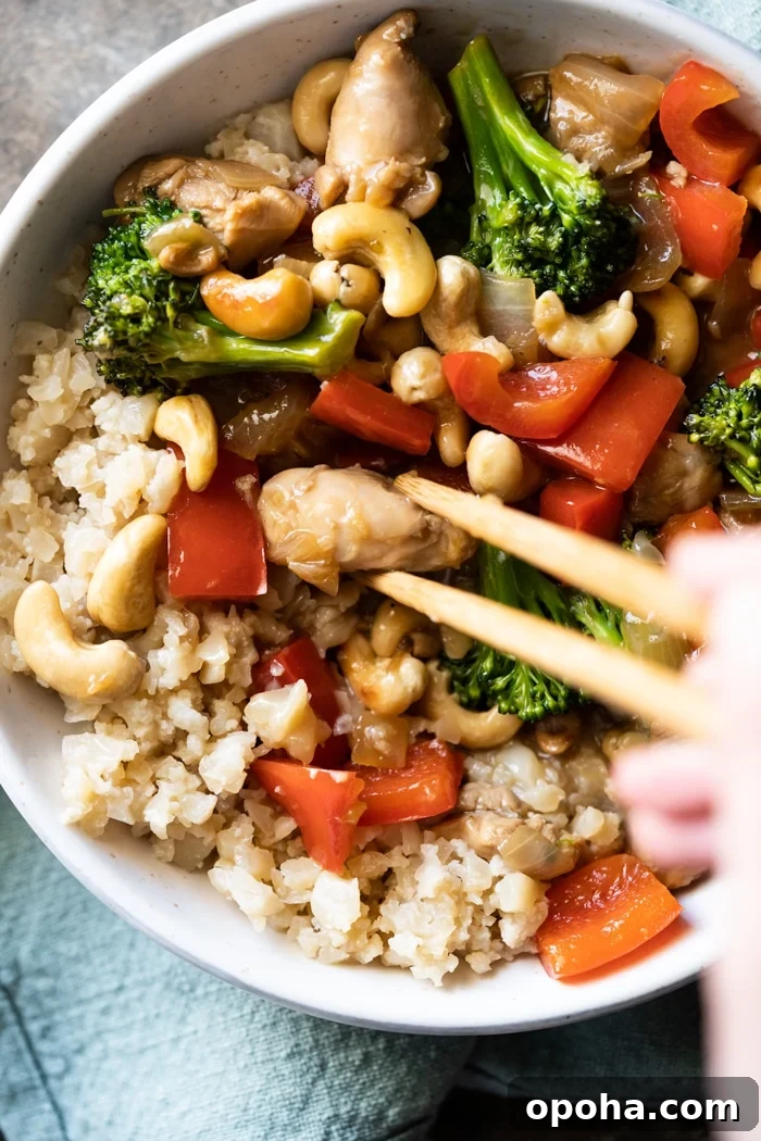 Keto & Paleo Cashew Chicken Recipe — Low-Carb Takeout Alternative 5 Eating paleo cashew chicken with chopsticks