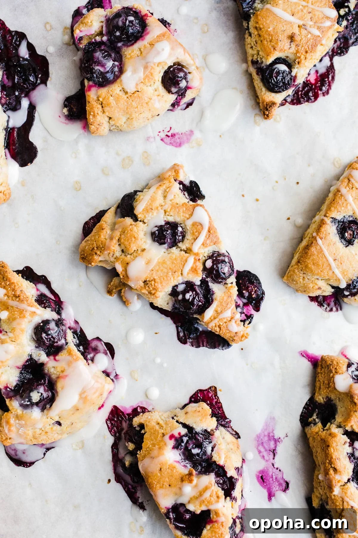 Scones with icing on parchment paper. 