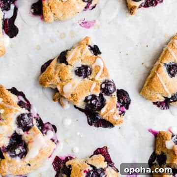Scones with icing on parchment paper.