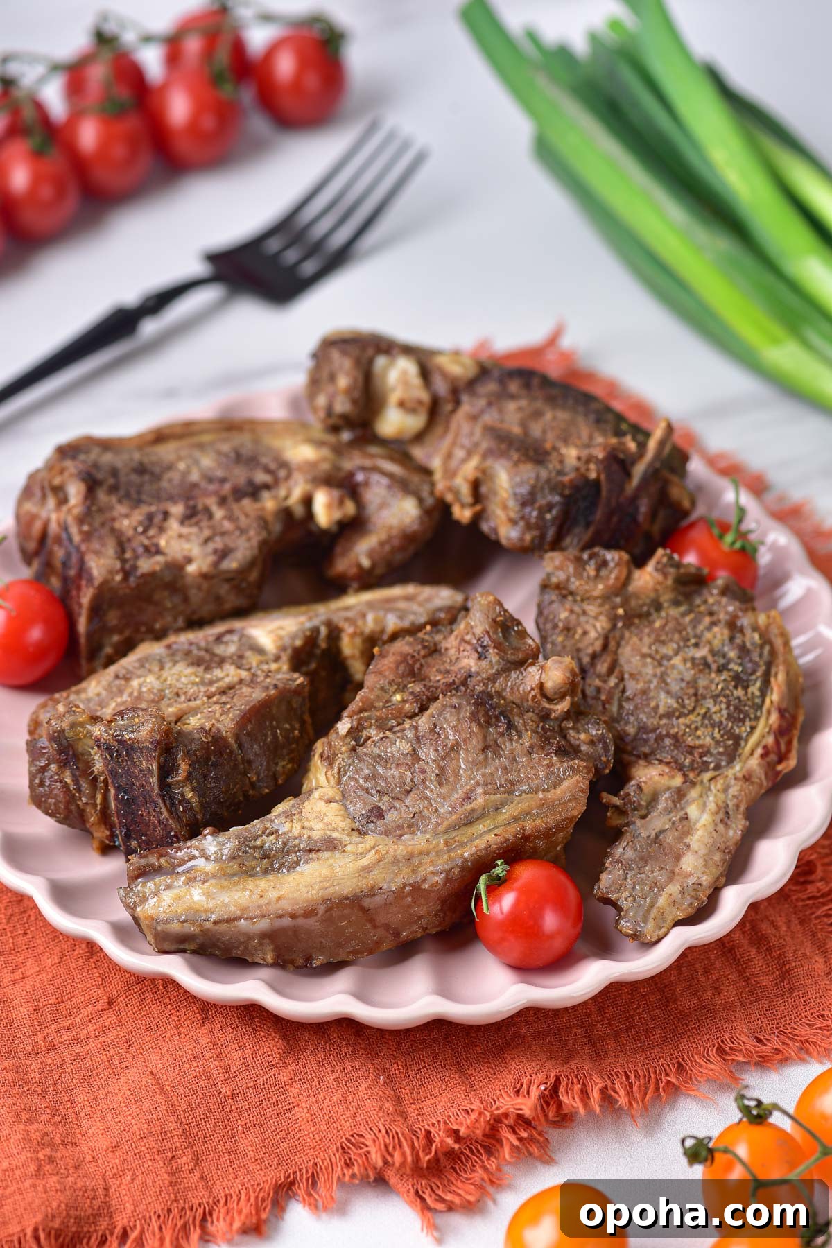 The completed air fryer lamb chops served on a white plate