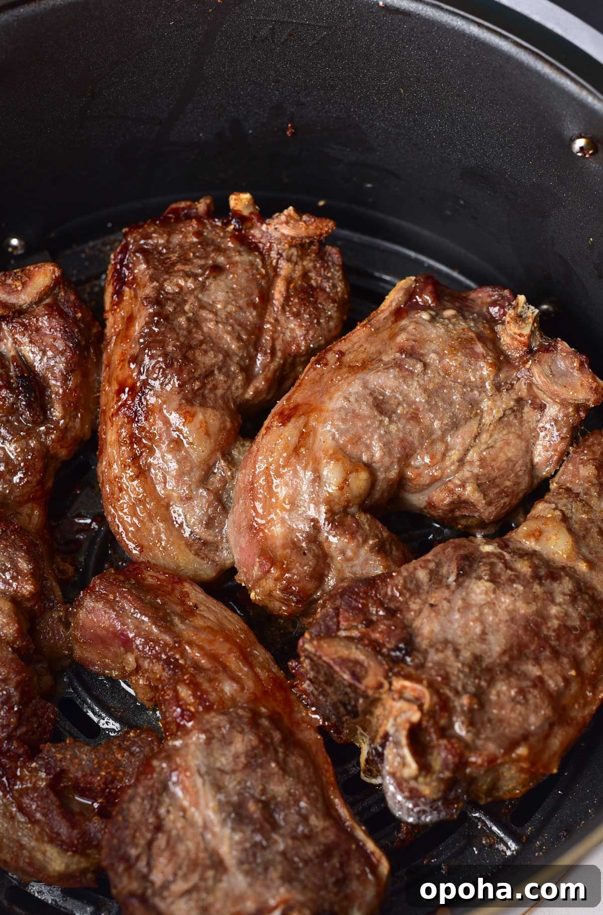close up view of the cooked lamb chops in the air fryer basket