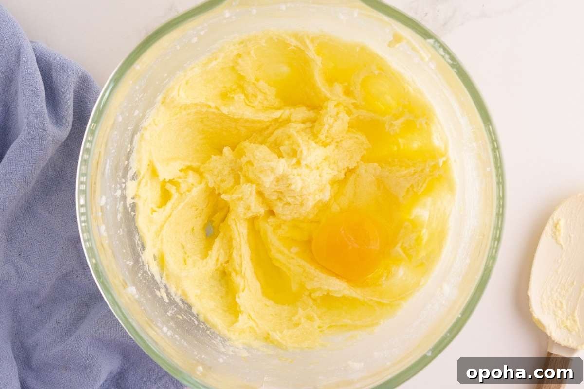 Classic Yellow Cake with Rich Chocolate Frosting Recipe 5 eggs partially added to mixing bowl.