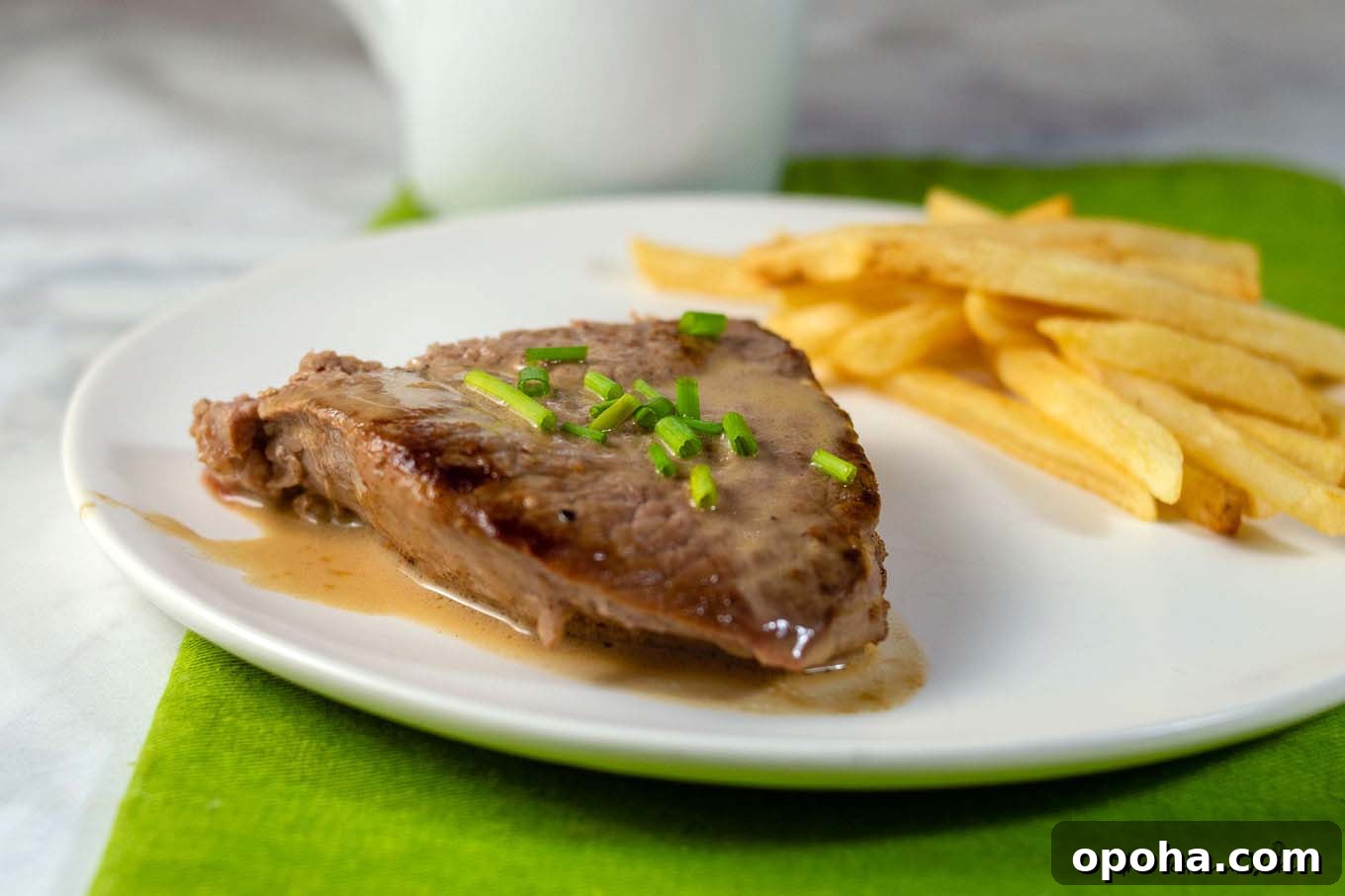 Whiskey Sauce Steak Recipe: Pan-Seared Steak with Rich Whiskey Glaze 2 A plate of steak with whiskey sauce and a side of French fries