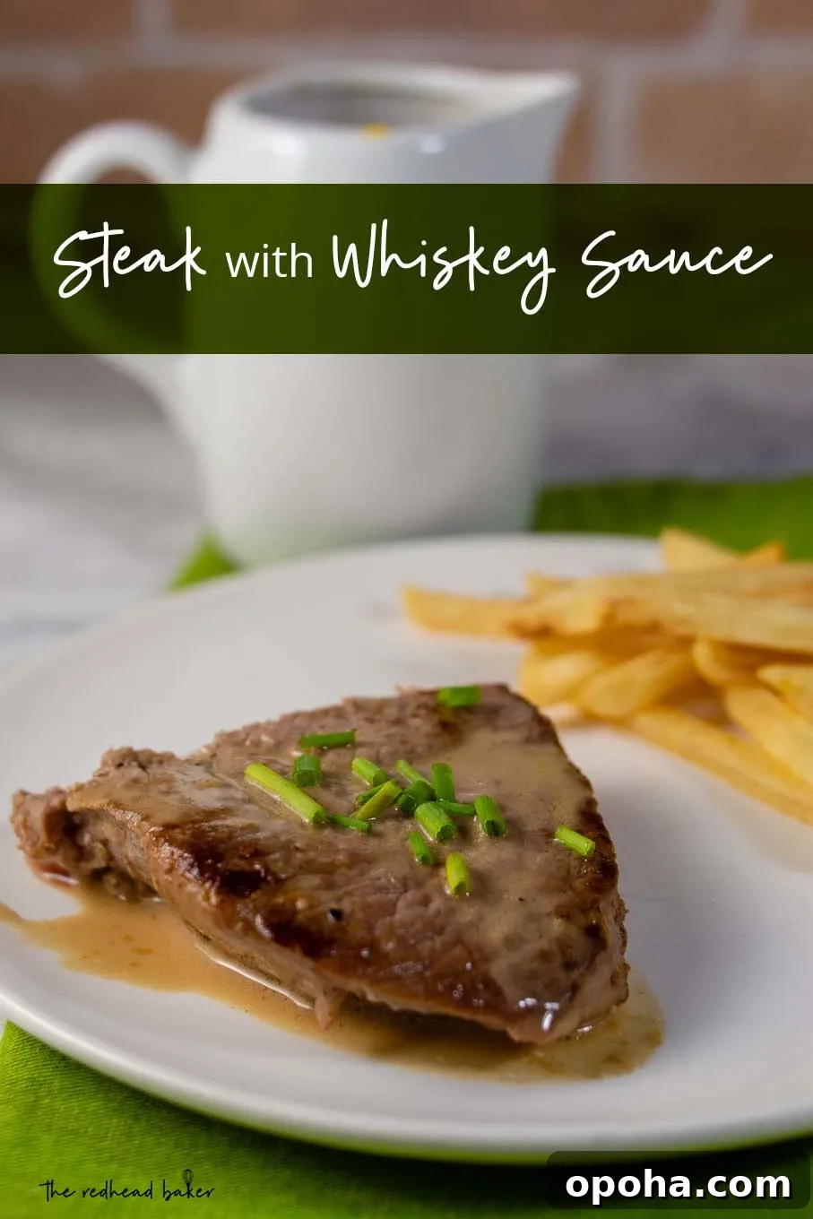 Whiskey Sauce Steak Recipe: Pan-Seared Steak with Rich Whiskey Glaze 5 A plate of steak with whiskey sauce and a side of French fries with a container of whiskey sauce in the background