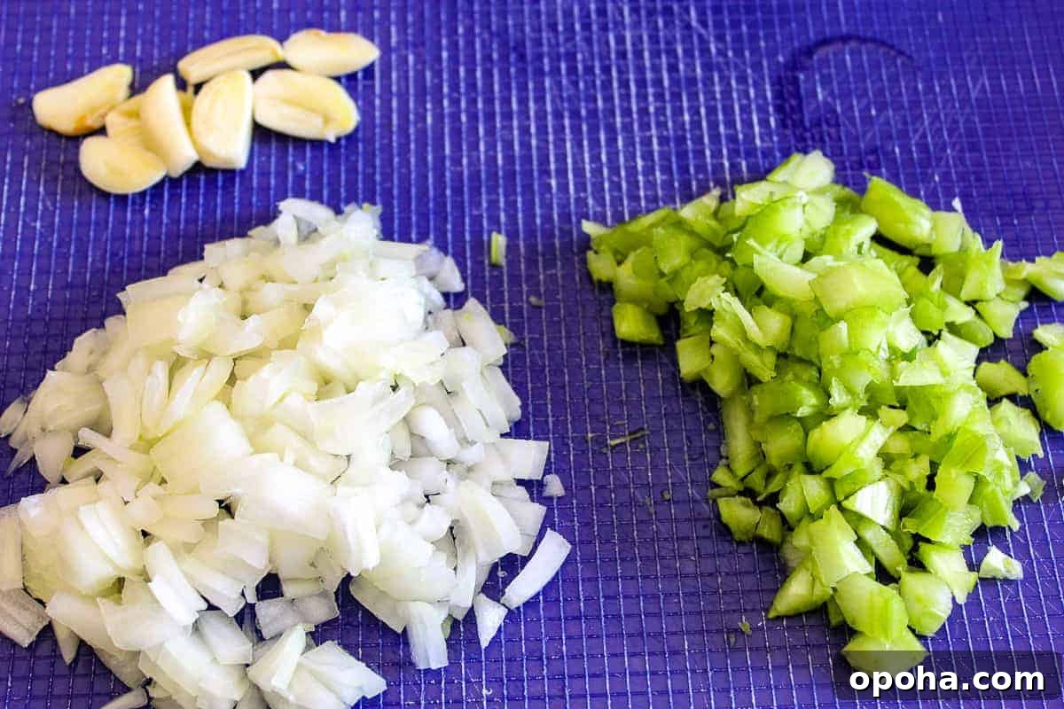 Velvety White Bean Soup with Garlic and Herbs 3 Chopped onion, celery and garlic on cutting board.