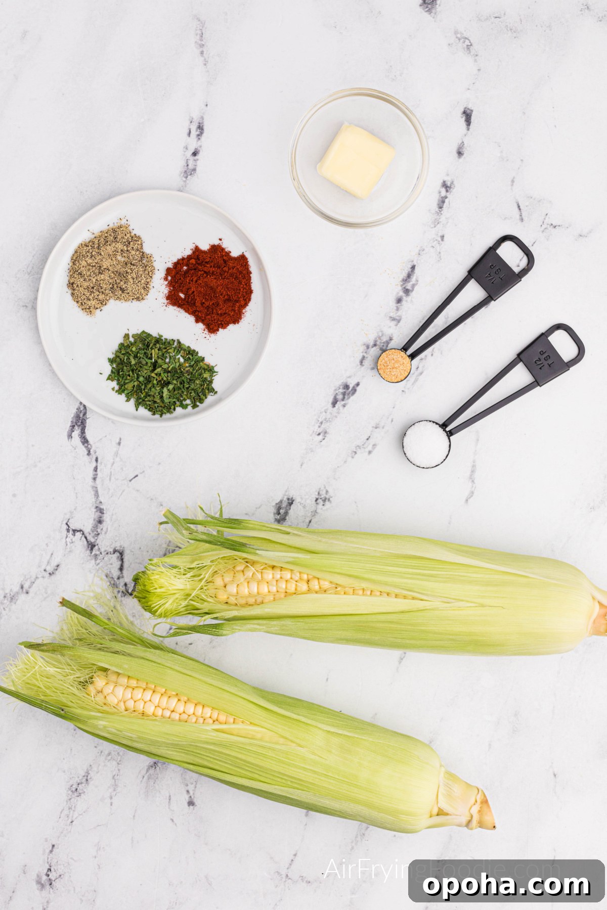 Crispy Air Fryer Corn Ribs Recipe 3 Seasonings on a plate, butter, and corn on a table.