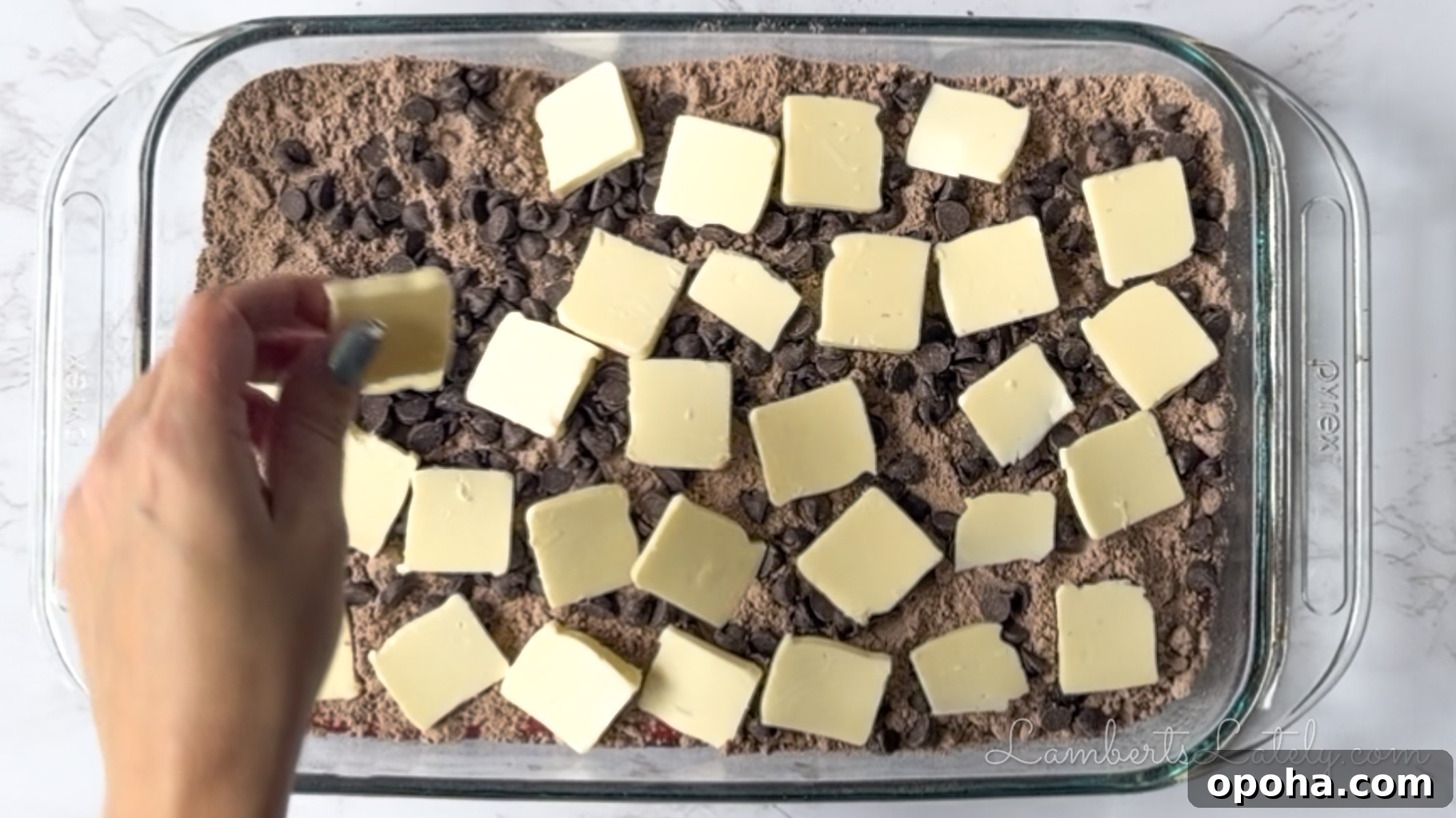 Decadent Chocolate Cherry Dump Cake Recipe for Chocolate Lovers 9 putting butter pats over cake mix and chocolate chips in a baking dish.