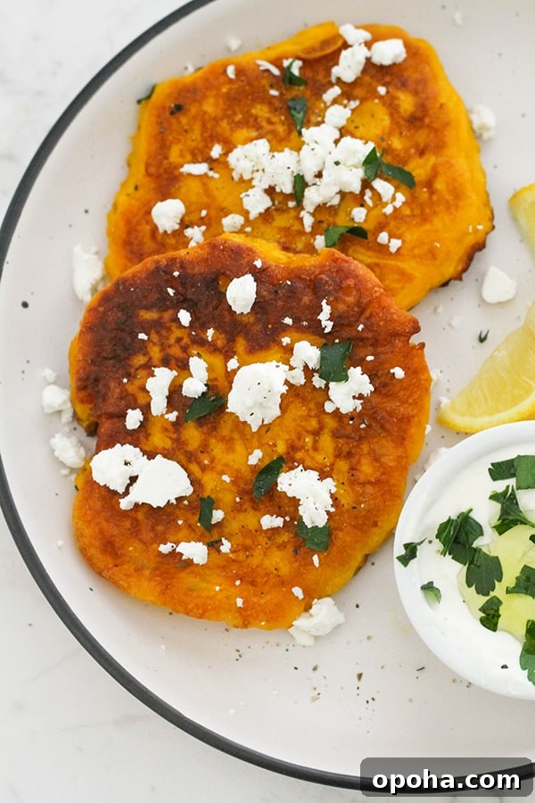 Crispy Pumpkin Fritters with Maple Cinnamon Glaze 2 two pumpkin fritters on a white plate topped with feta and parsley.