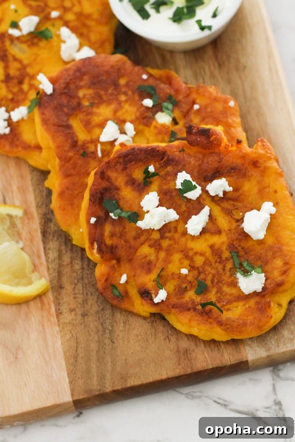 Crispy Pumpkin Fritters with Maple Cinnamon Glaze 3 pumpkin fritters laid on top of a wooden board.