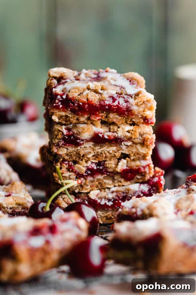 Chewy Cherry Pie Bars with Buttery Crust Recipe 10 A stack of cherry pie bars with almond glaze on top.