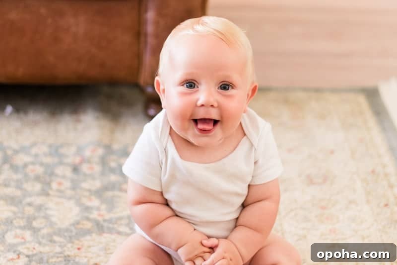 Treating Baby Cradle Cap with Coconut Oil: Gentle Step-by-Step Guide 2 7 month old baby wearing a white onesie sitting on rug.