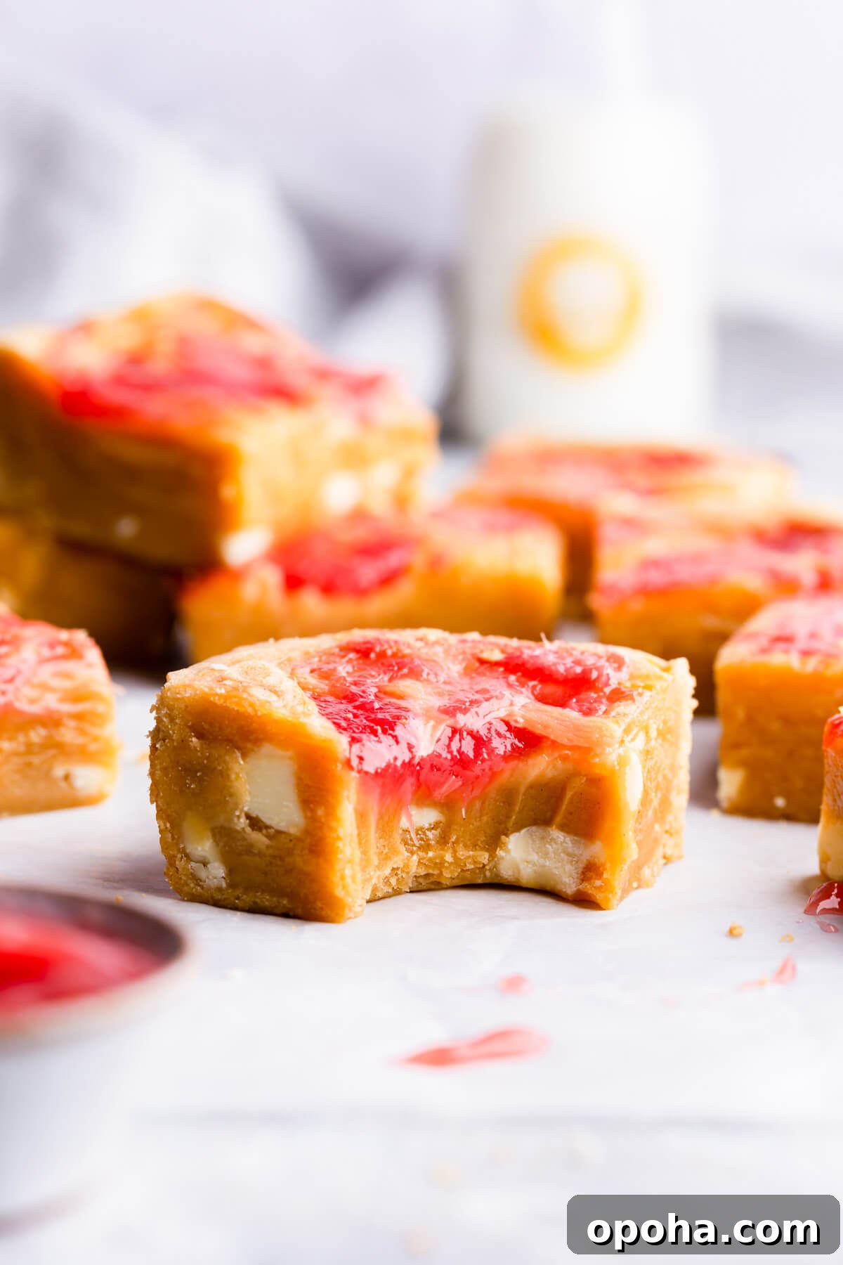 Rhubarb and Custard Blondies Recipe 14 straight ahead angle super close up of a square slice of rhubarb blondie cake with bite taken out