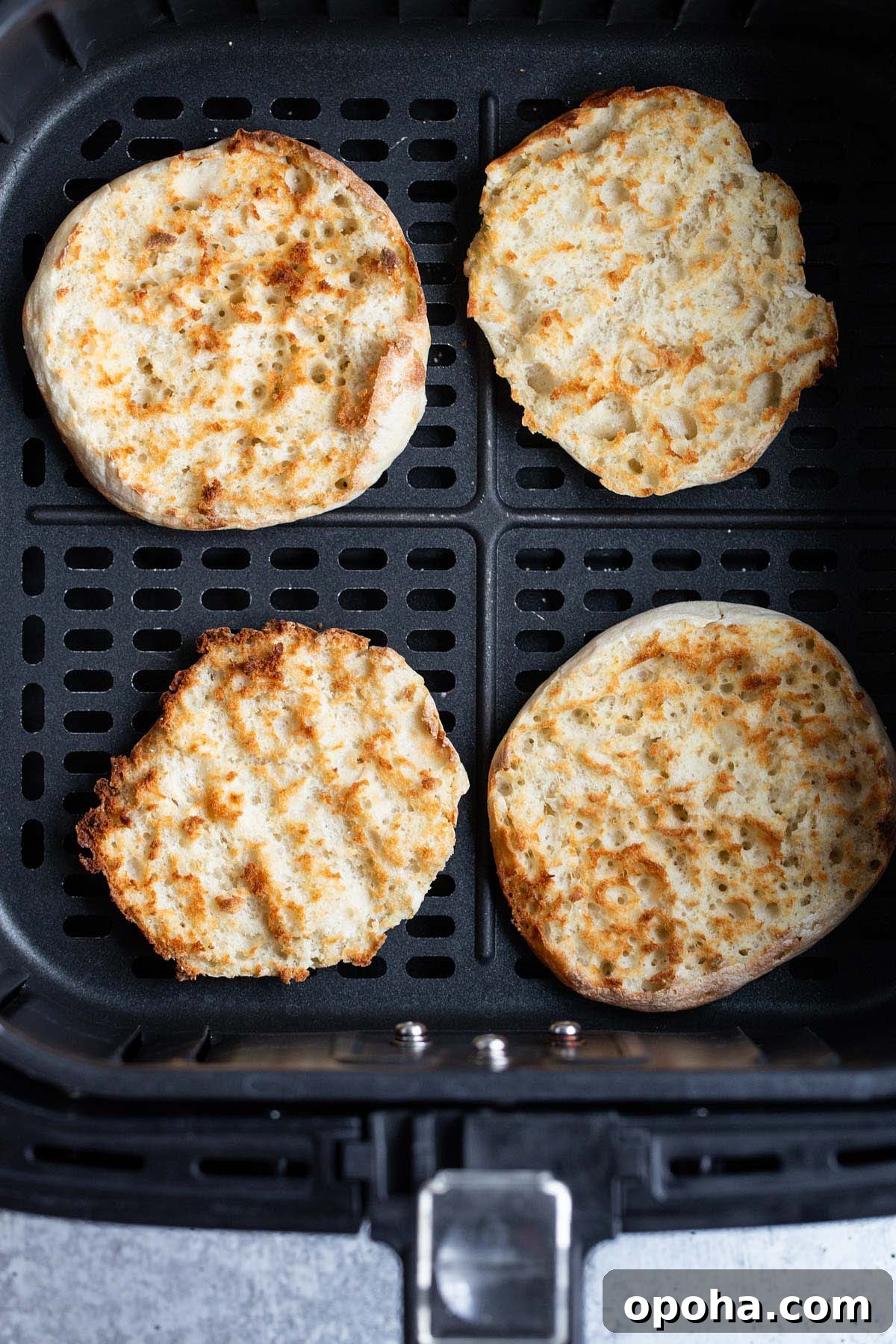 Crispy Air Fryer English Muffins Recipe 5 Toasted English muffin in air fryer basket.