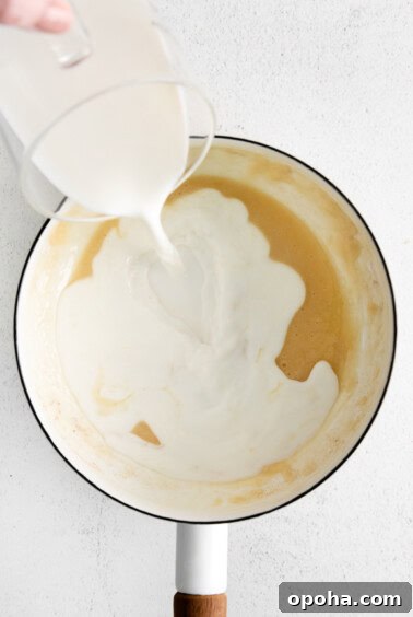 Creamy Cheddar Cheese Sauce Recipe for Smooth, Velvety Texture 6 adding milk to pot.