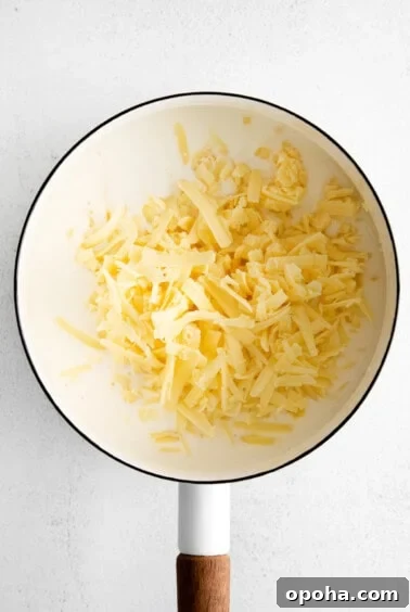 Creamy Cheddar Cheese Sauce Recipe for Smooth, Velvety Texture 7 cheese and roux in pot.