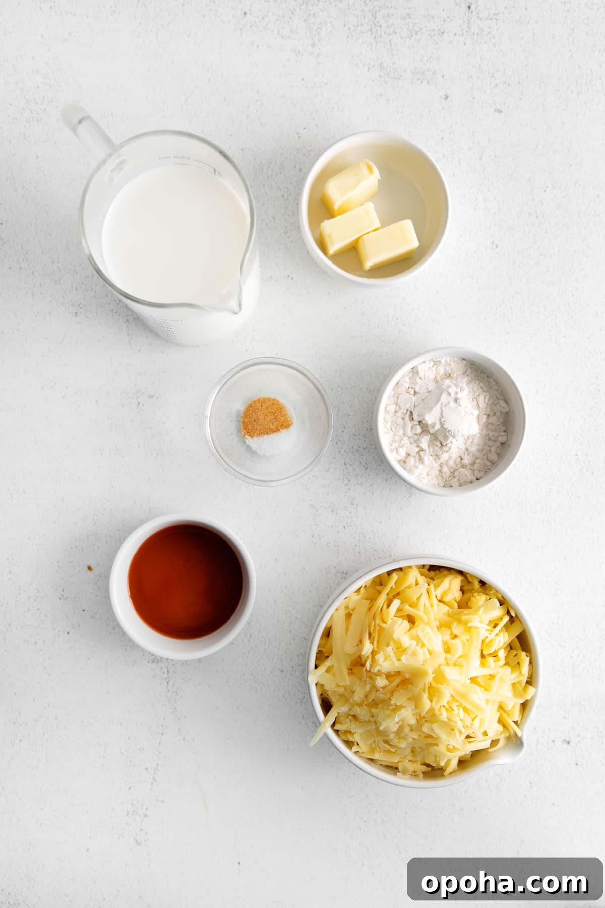 Looking for a classic cheddar cheese sauce recipe? This cheese sauce is perfect for dipping chips, topping veggies, or mixing with noodles. It's truly an all-purpose sauce. ingredients on countertop.