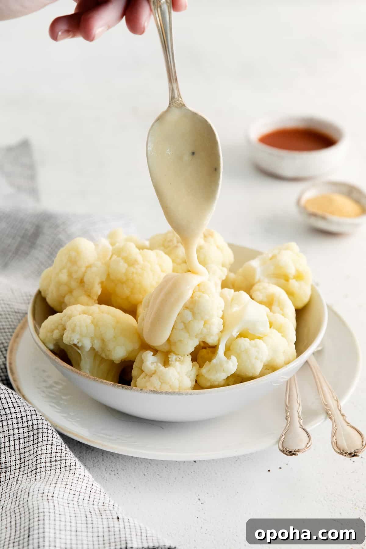 Looking for a classic cheddar cheese sauce recipe? This cheese sauce is perfect for dipping chips, topping veggies, or mixing with noodles. It's truly an all-purpose sauce. serving cheddar cheese sauce on top of cauliflower.