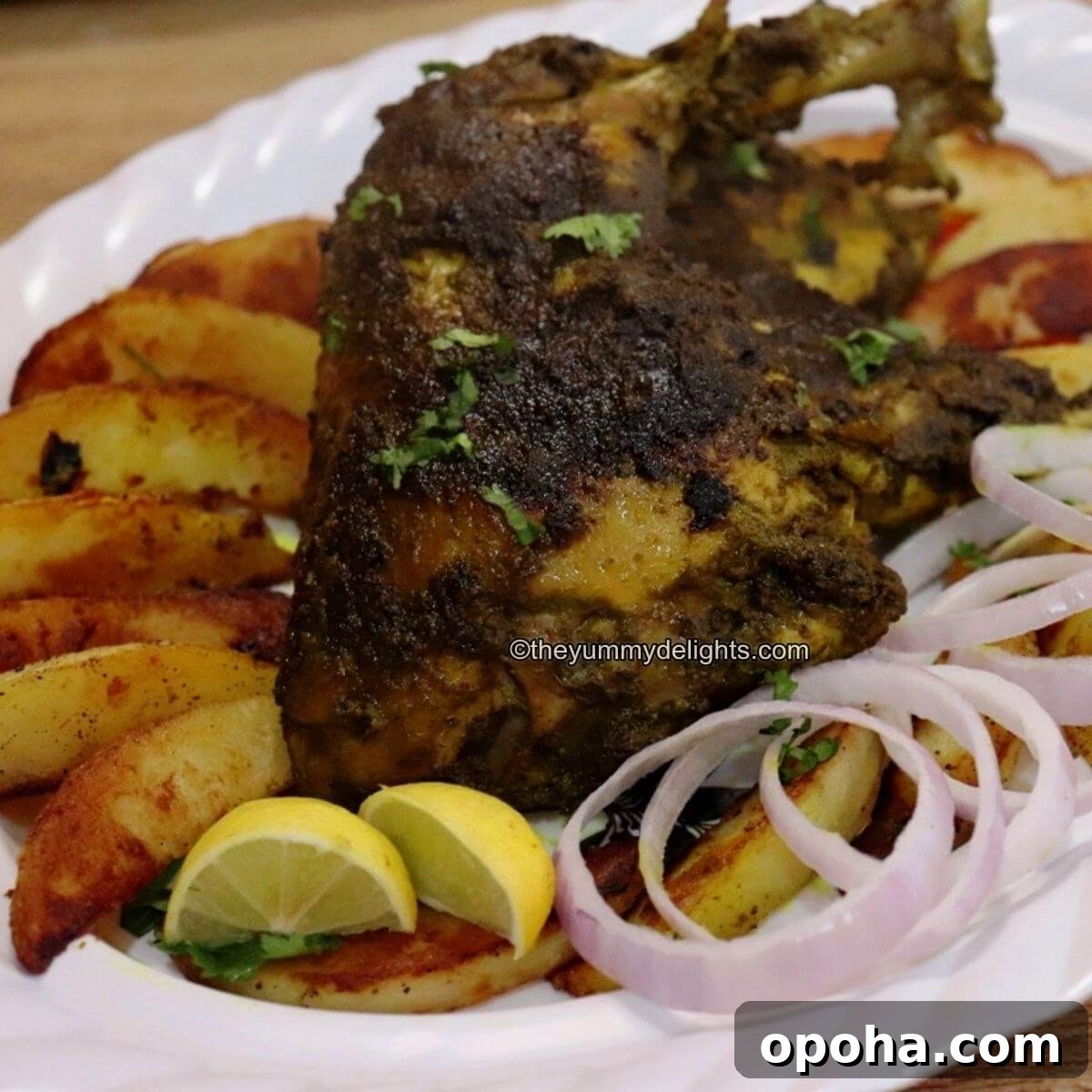 Goan Chicken Cafreal (Galinha Cafreal) Recipe — Authentic Spice Rub 11 chicken cafreal served with potato wedges, onion rings, and lemon wedges on a white plate.
