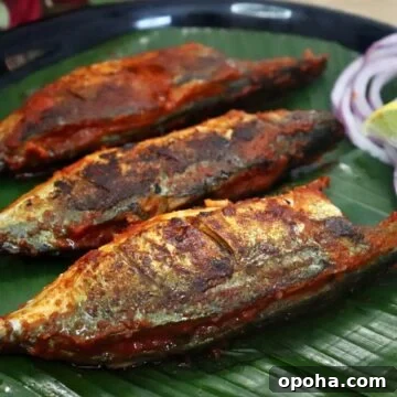 recheado mackerels served on a plate with lemon wedges and onion rings. Recheado masala fish recipe.