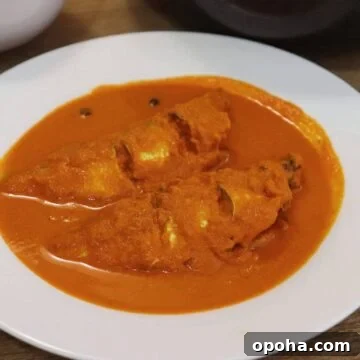 goan fish curry with coconut served in a white bowl.