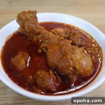 malvani chicken curry in a white colored bowl.