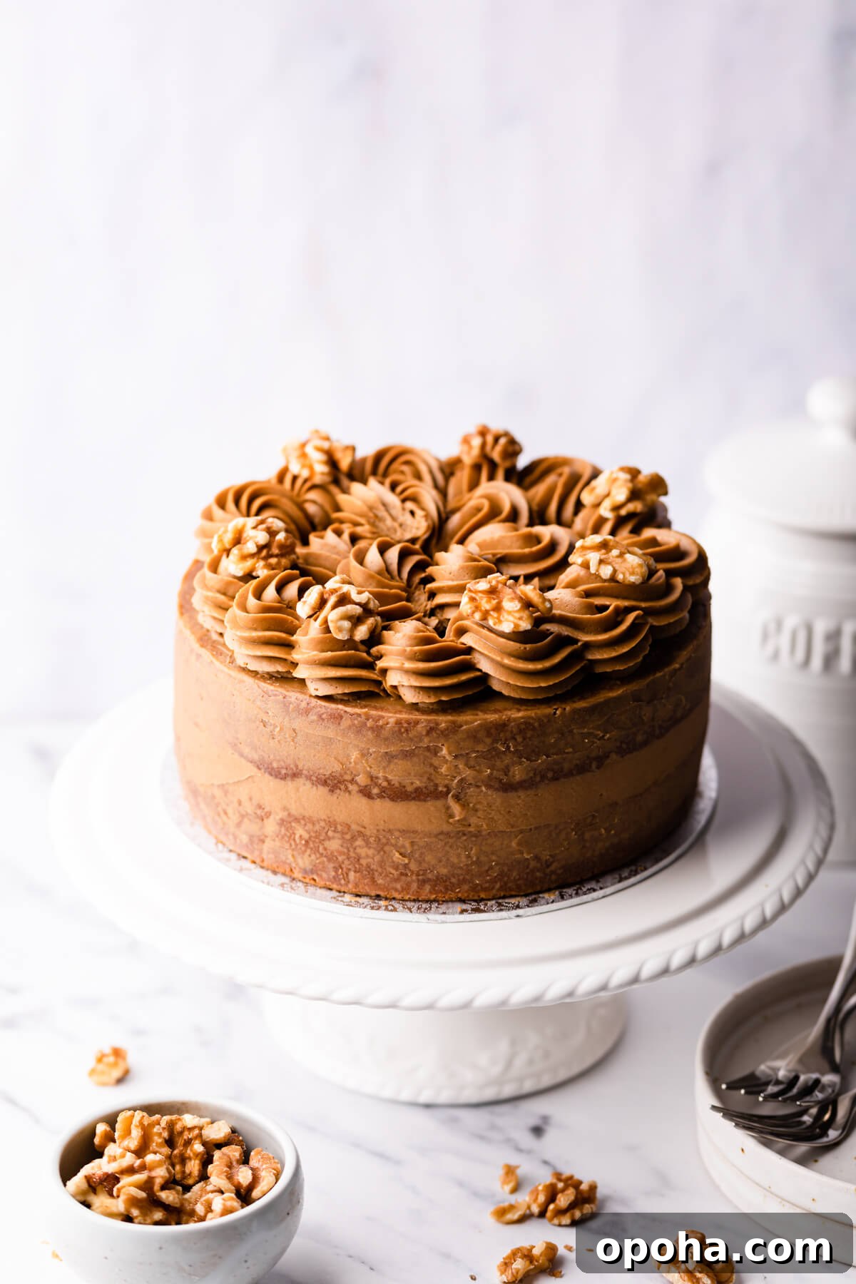 Decadent Coffee and Walnut Cake Recipe for Coffee Lovers 2 coffee and walnut cake topped with coffee buttercream and walnut halves.