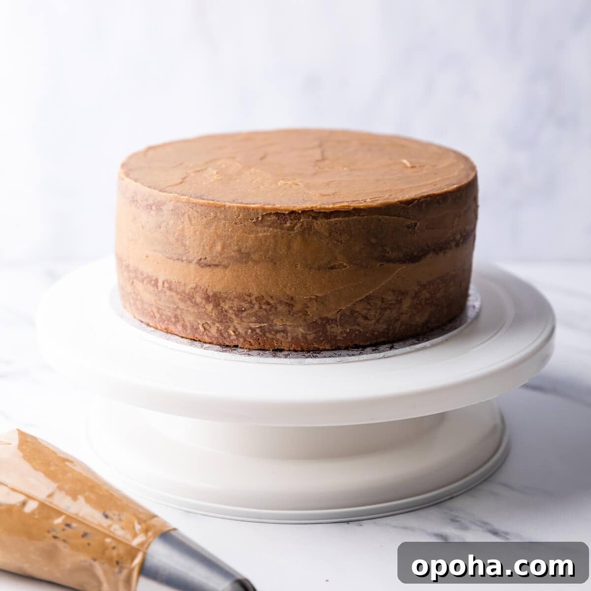 Decadent Coffee and Walnut Cake Recipe for Coffee Lovers 9 coffee cake with crumb coating on a cake turntable.