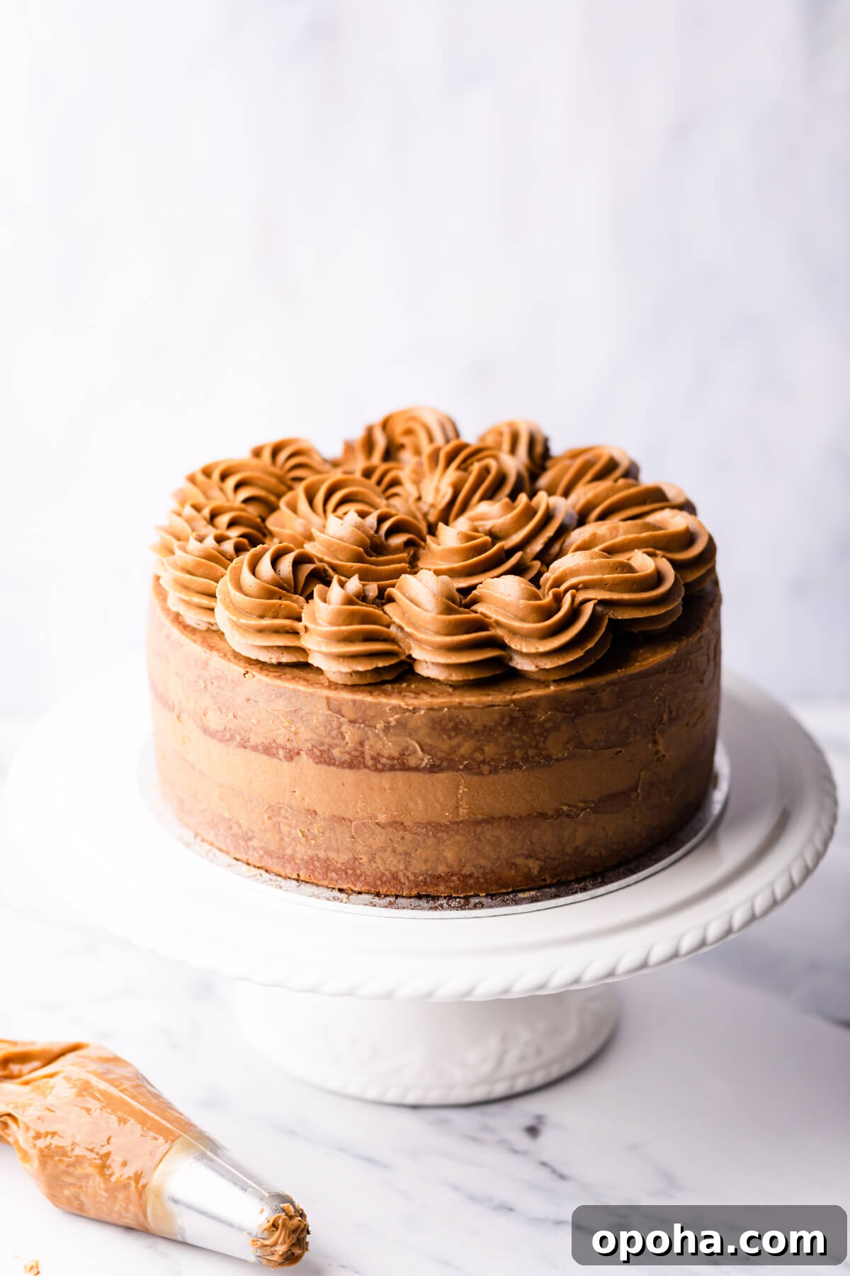 Decadent Coffee and Walnut Cake Recipe for Coffee Lovers 10 coffee and walnut cake on a white cake stand.