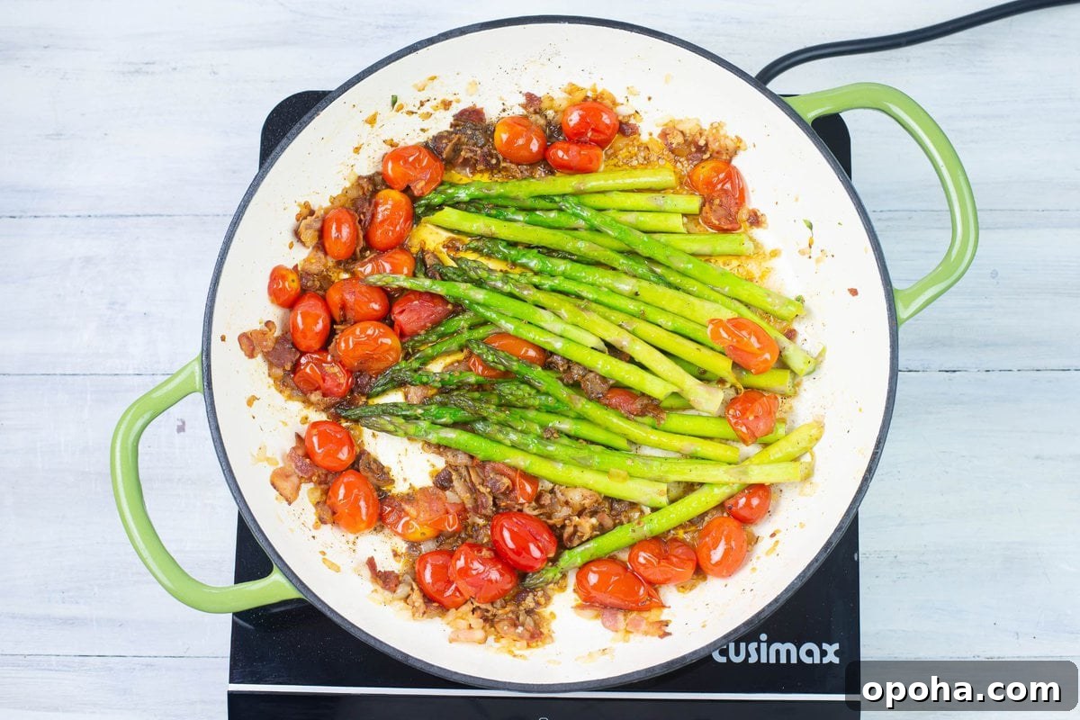 Sautéed Asparagus, Tomatoes & Bacon Skillet Recipe 8 Cooked asparagus with tomatoes and bacon in a skillet.