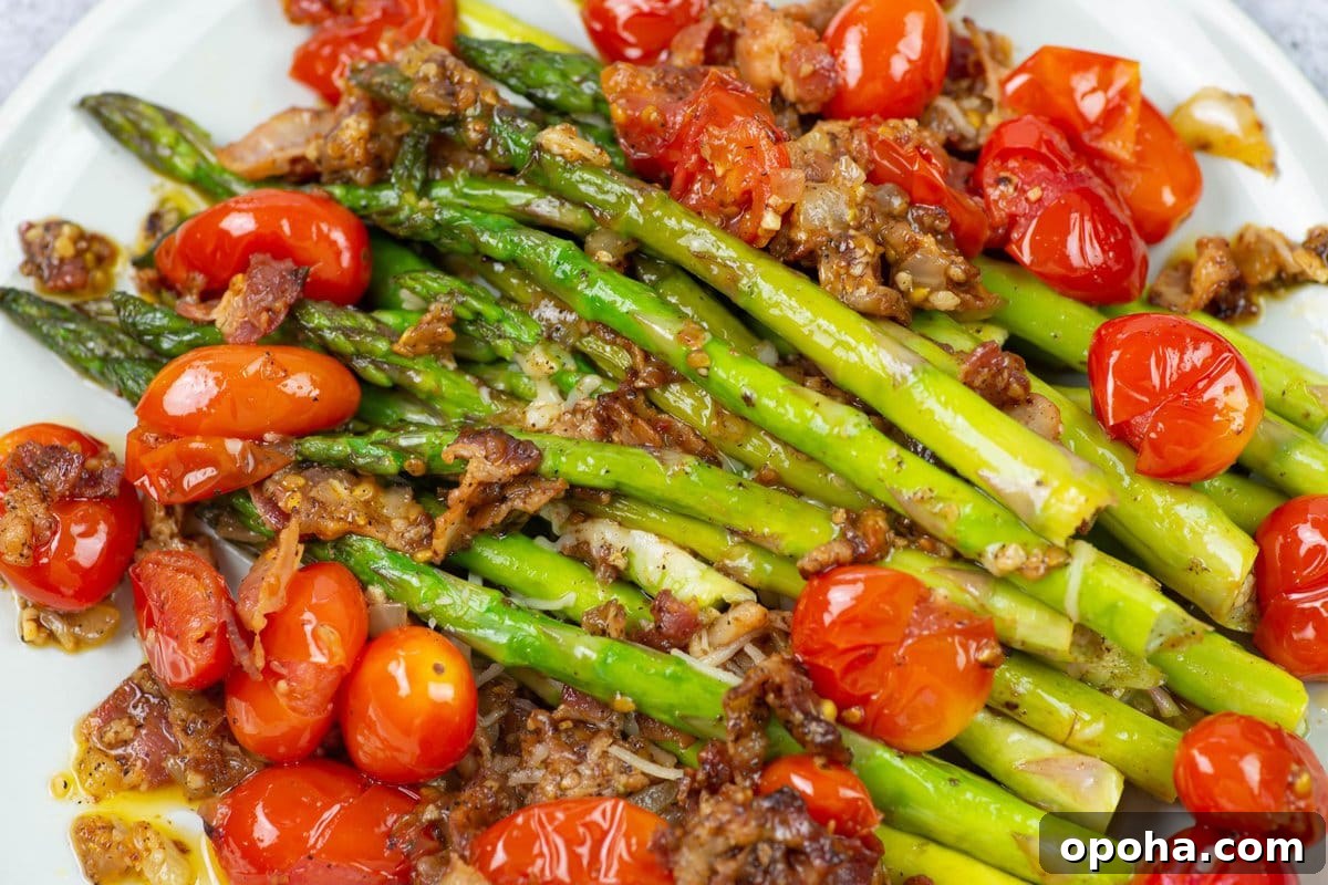 Sautéed Asparagus, Tomatoes & Bacon Skillet Recipe 9 Closeup image of cooked asparagus spears on a bed of cooked grape tomatoes seasoned with bacon.
