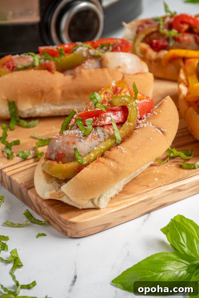 Slow Cooker Sausage and Peppers with Onions and Tomato Sauce 7 Close up view of an Italian sausage in a bun with peppers and onions.
