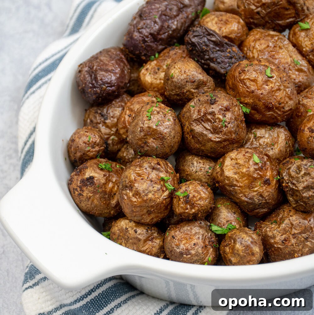 Slow Cooker Sausage and Peppers with Onions and Tomato Sauce 8 Air fryer baby potatoes in a white ceramic serving dish covered in salt and garnished with chopped parsley.