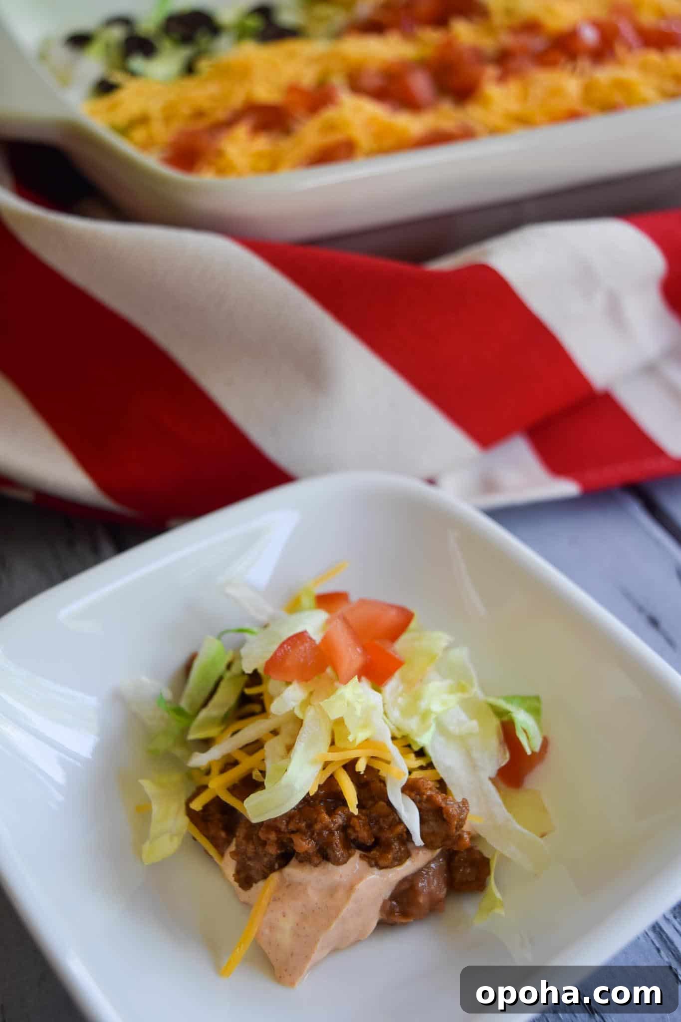 Taco dip spooned into a white bowl ready to be eaten close up view