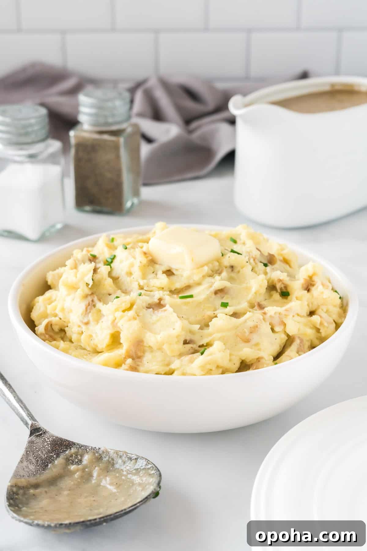 Creamy Mashed Potatoes with Sour Cream and Chives 11 mashed potatoes in a bowl topped with butter and chives