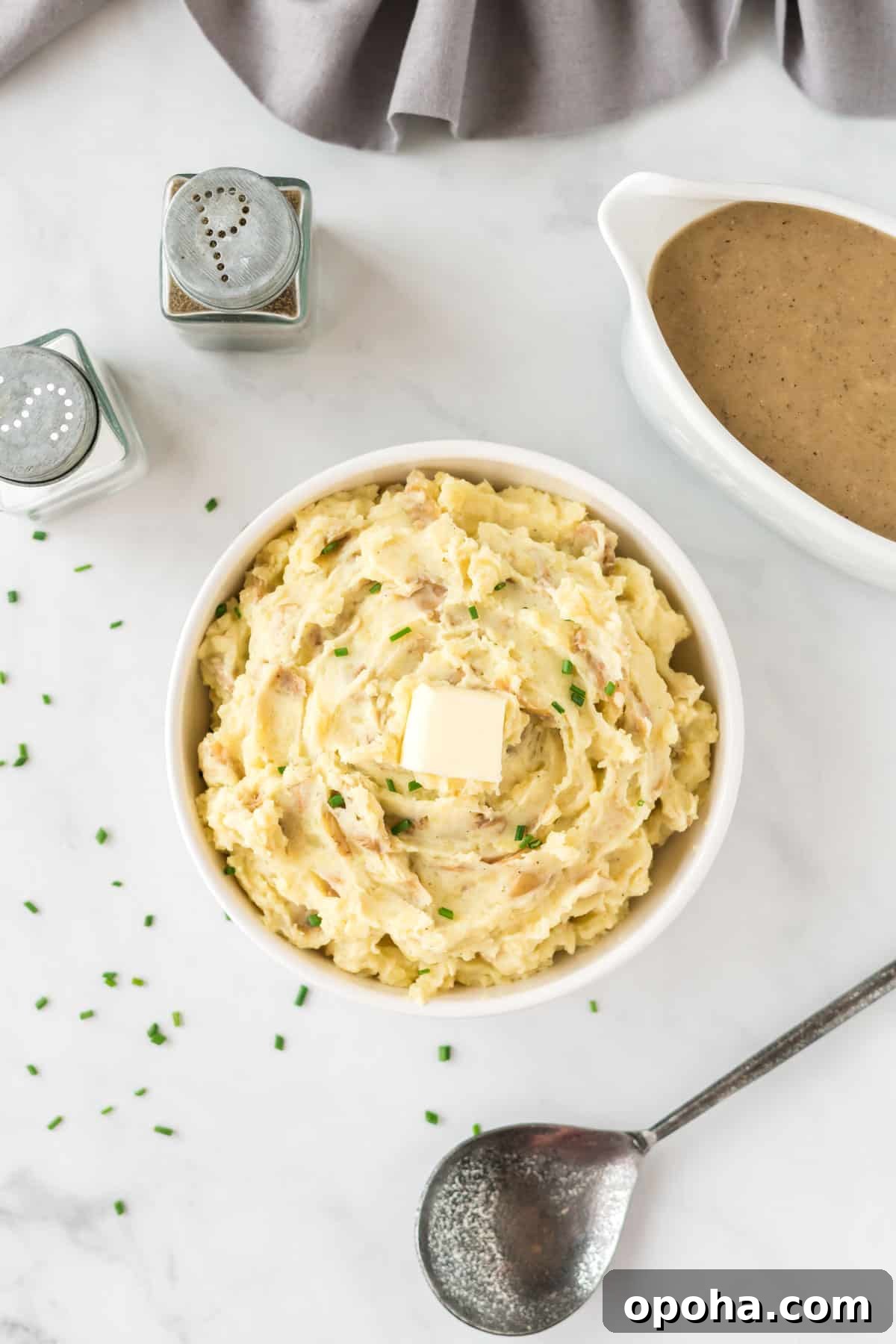 Creamy Mashed Potatoes with Sour Cream and Chives 13 mashed potatoes in a bowl topped with butter and chives