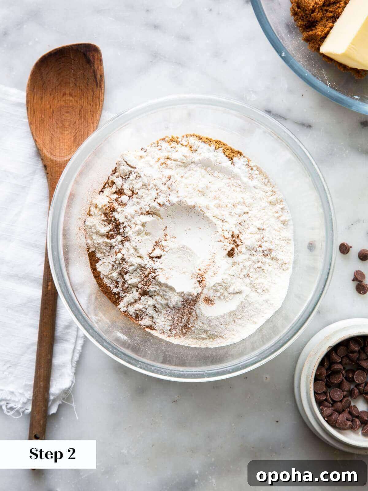 Pumpkin Chocolate Chip Cookie Recipe — Soft, Spiced & Gooey 5 A bowl filled with dry ingredients for pumpkin chocolate chip cookies, including flour and spices.