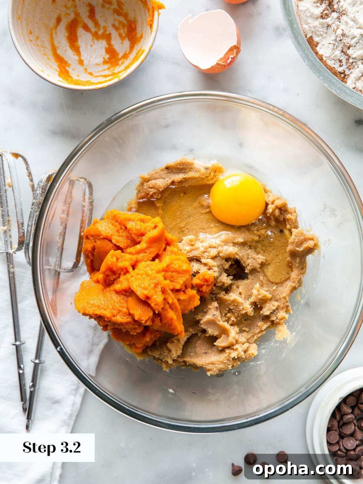 Pumpkin Chocolate Chip Cookie Recipe — Soft, Spiced & Gooey 7 The process of adding pumpkin puree and an egg to the dry ingredients to make pumpkin chocolate chip cookie dough.