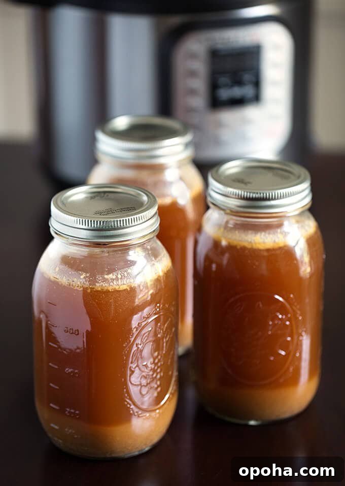Instant Pot Beef Bone Broth Recipe for Rich, Collagen-Packed Stock 2 Three jars of Instant Pot Bone Broth with lids on and pressure cooker in the background