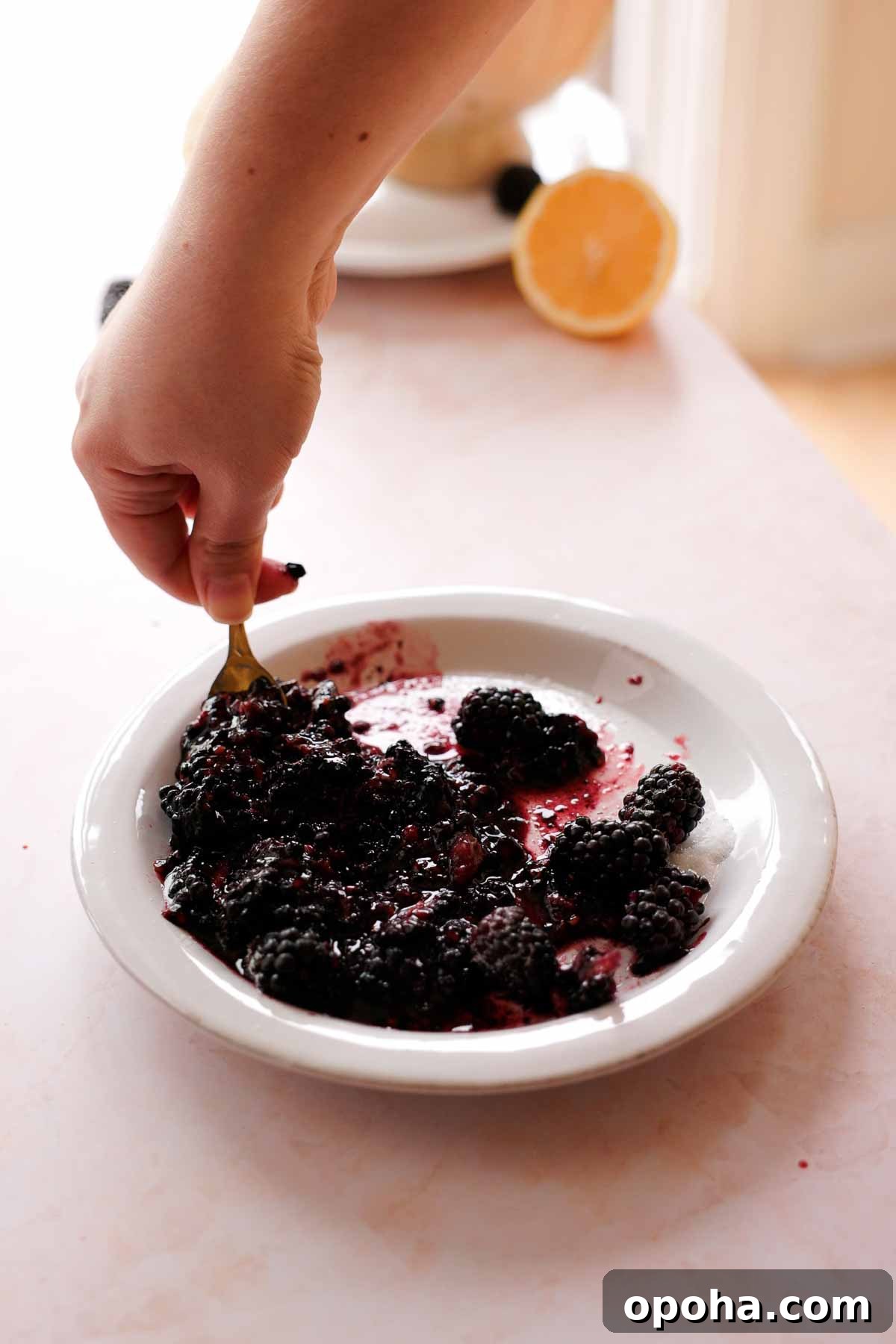 mashing blackberries and sugar on a plate