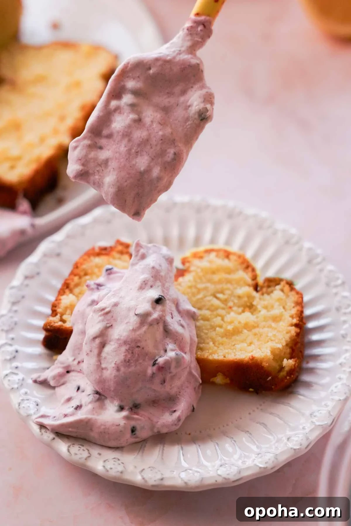 slice of lemon pound cake with scoops of blackberry whipped cream